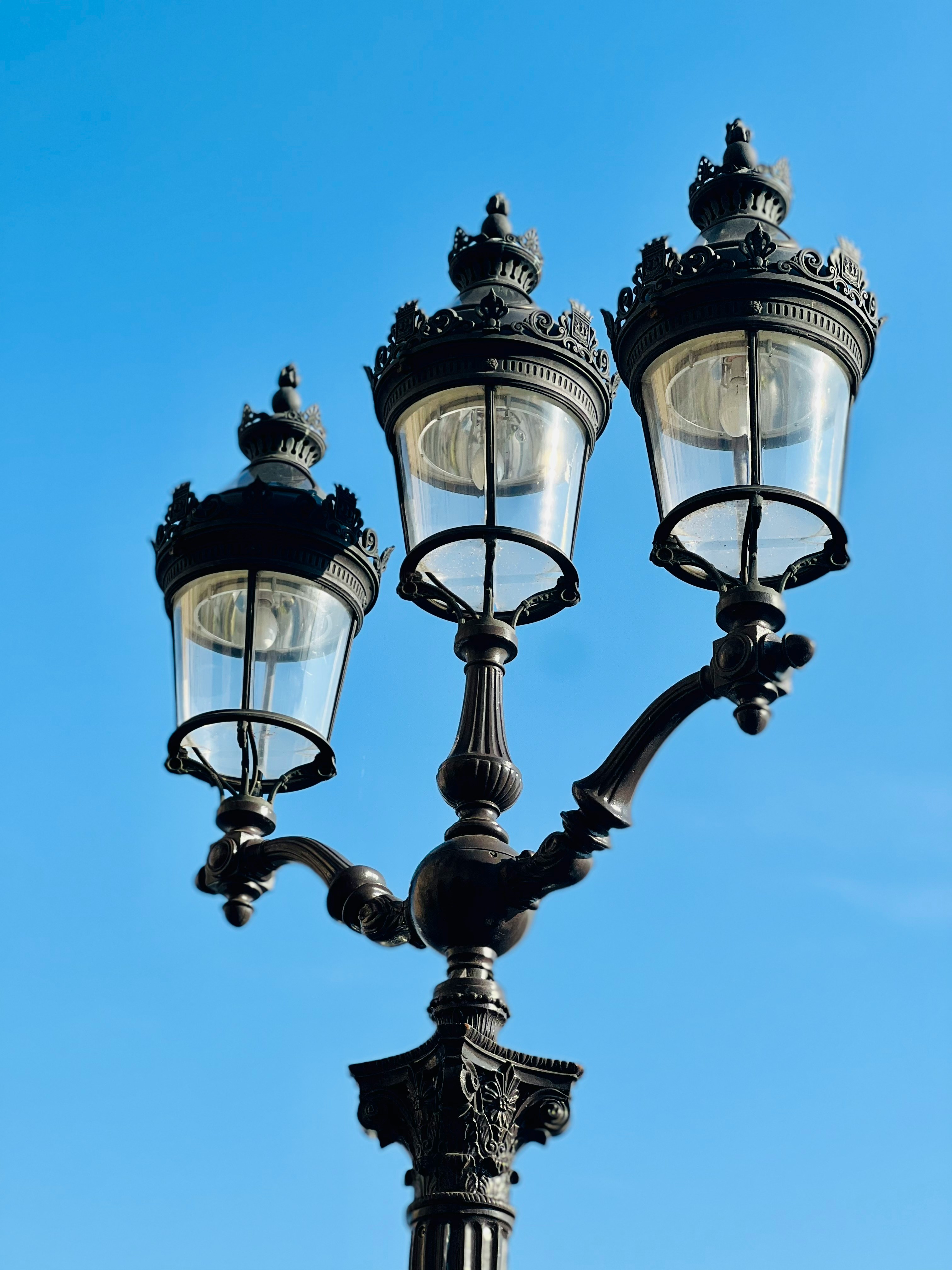 A Victorian style tripronged lamppost with an askew perspective