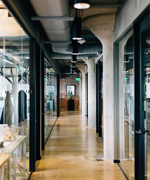 an office hallway with an exposed brick wall at the end