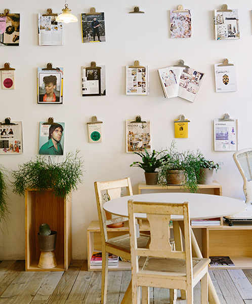 a small table with 3 chairs, placed in front of a photo wall
