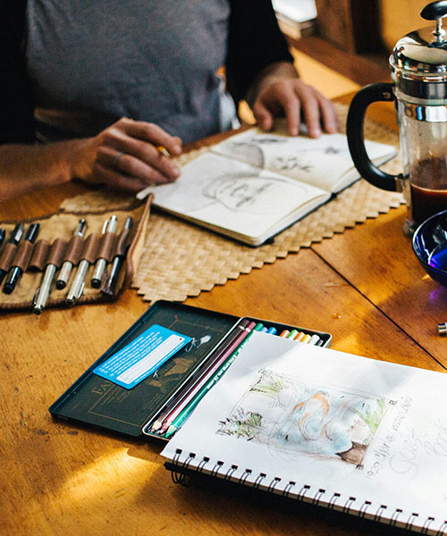 Man sketching portraits on a table