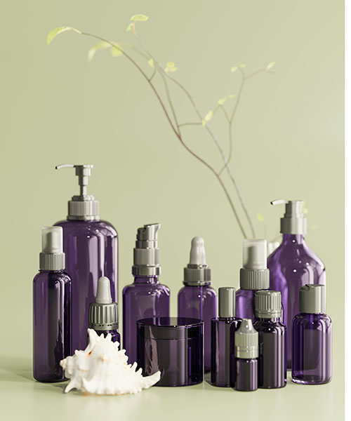 12 purple bottles with silver caps and pumps are displayed in front of a sage green background along with a white shell in front and a single branch behind.