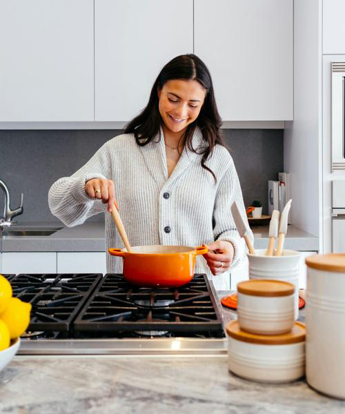 Girl cooking in a kitchen with pots on the stove